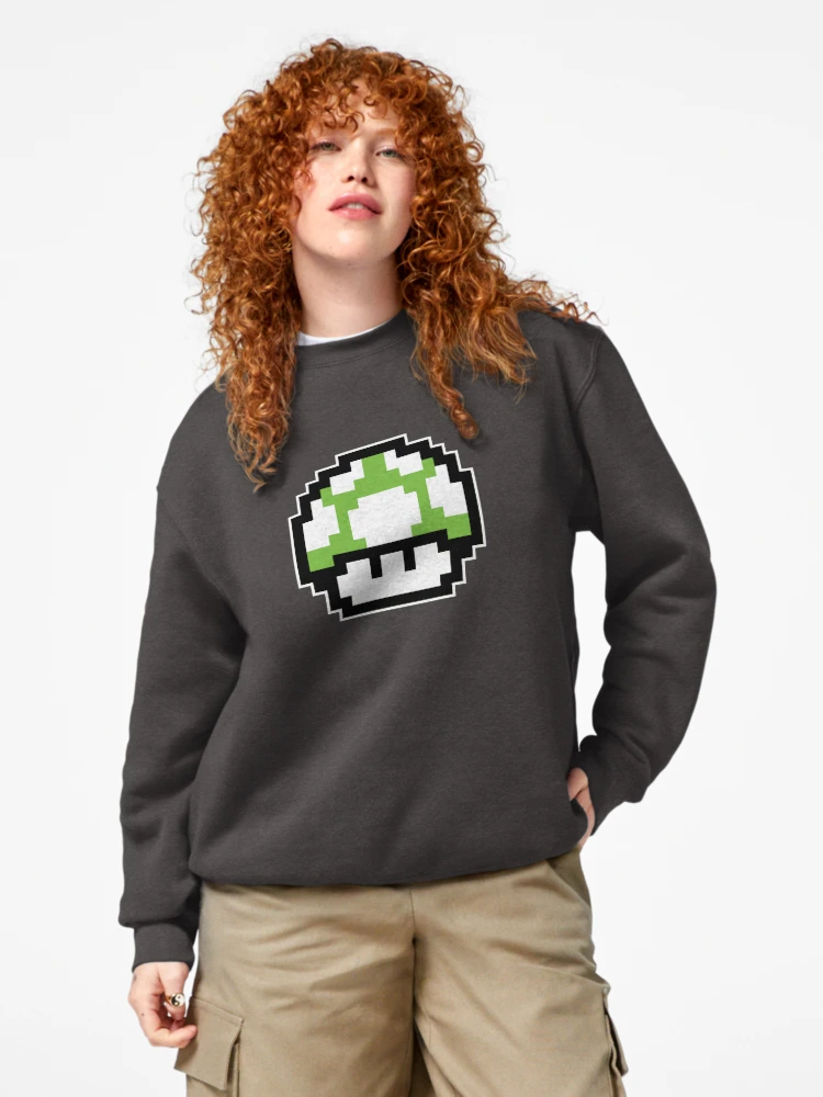 Femme qui porte un sweat gris anthracite avec personnage champignon vert Mario