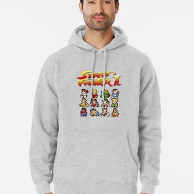 Homme qui porte un sweat gris clair Street Fighter avec tous les personnages pixelisés