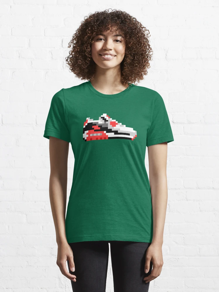 Femme qui porte un tee-shirt vert sapin avec une basket en pixels rouge et noire