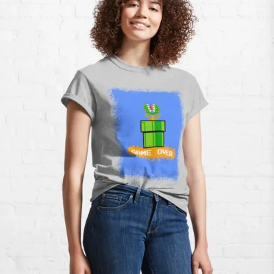 Femme qui porte un tee-shirt gris clair Super Mario avec le personnage de la plante Piranha bleu et verte