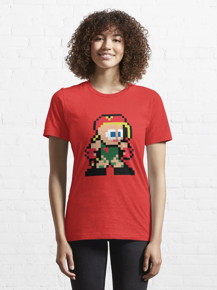 Femme qui porte un tee-shirt rouge vif Street Fighter avec le personnage Cammy en pixels jaune et rouge