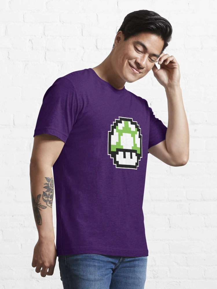 Homme qui porte un tee-shirt violet Super Mario avec le personnage champignon vert en pixels