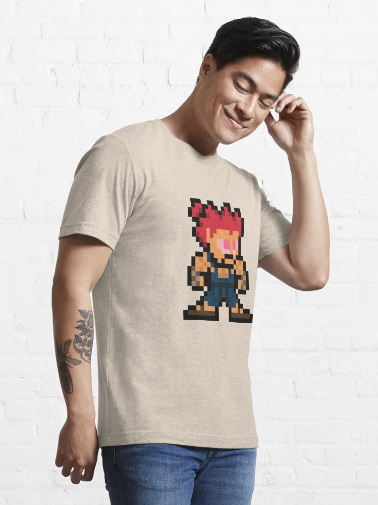 Homme qui porte un tee-shirt beige Street Fighter avec le personnage Akuma en pixels rouge et bleu